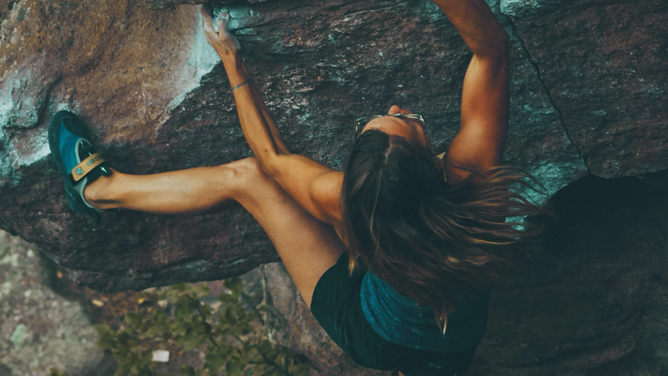 Woman bouldering with sunglasses