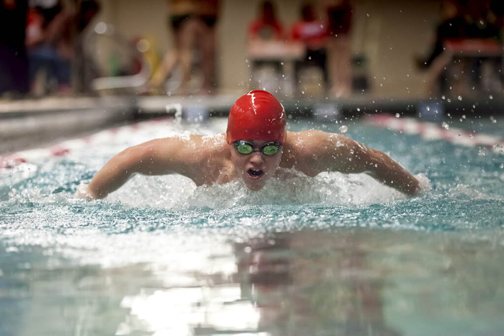 Young boy swimming butterfly stroke for school sports