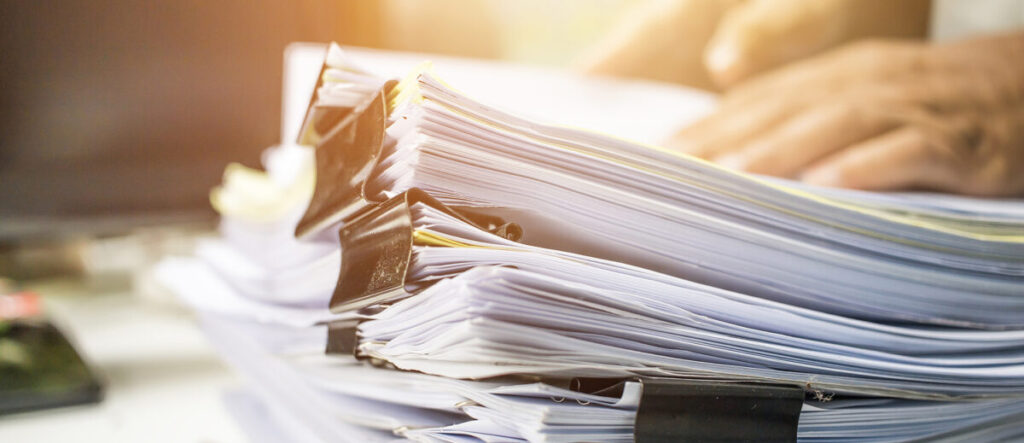 Businessman hands searching information in Stack of papers files
